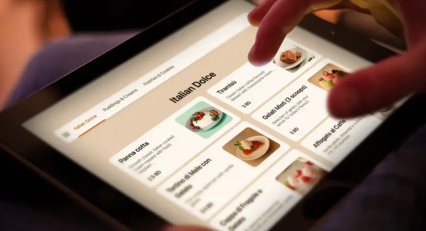 Tablet displaying a TableQR menu with Italian desserts as a user scrolls through panna cotta, tiramisu and other sweet items.