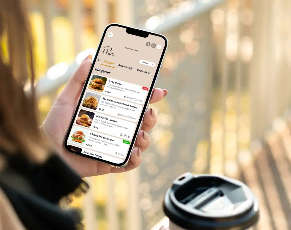 A woman in a restaurant holds her phone to view a digital menu and place an order.