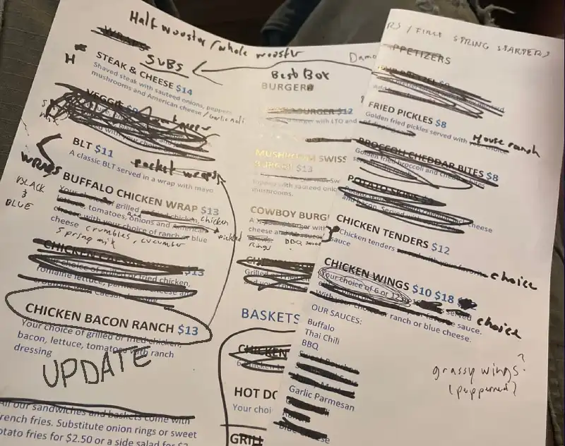 Paper restaurant menu with crossed-out prices showing why digital menus are needed